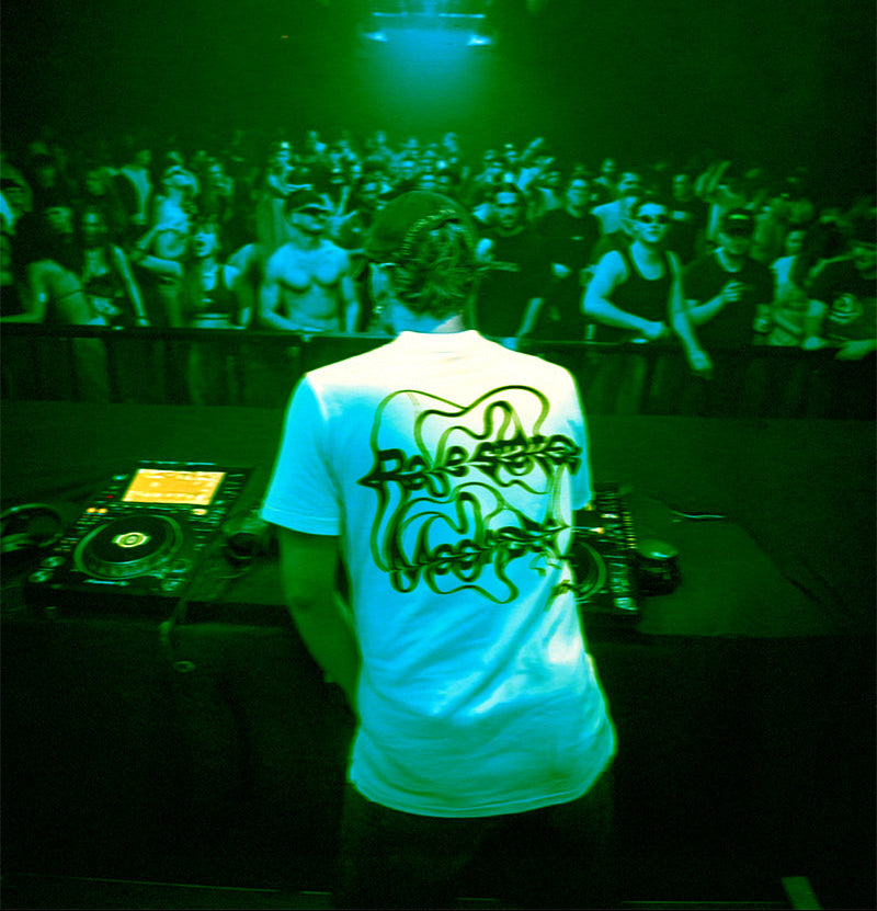 DJ portant un t-shirt Chaos devant une foule en soirée techno underground